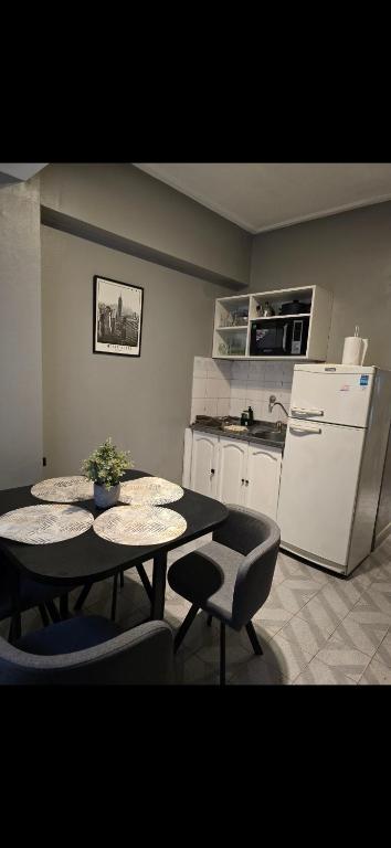 a kitchen with a table and two chairs and a refrigerator at Danella in San Miguel de Tucumán