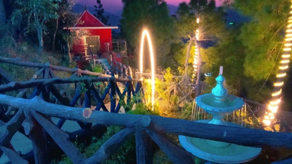 a fountain in the middle of a garden at night at Shaantvan Homestay-Near Bhalughar Waterfall-Mukteshwar in Mukteshwar
