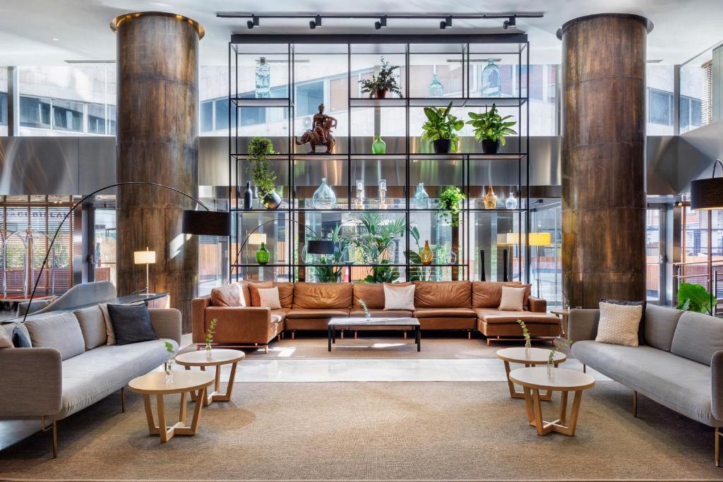 a lobby with couches and tables in a building at Meliá Madrid Princesa in Madrid