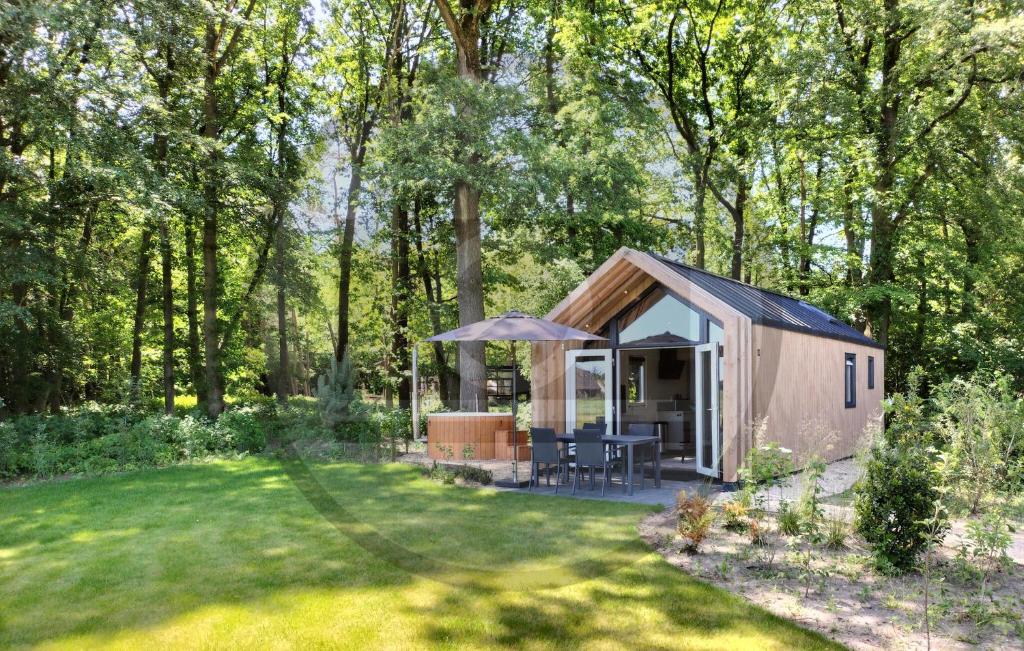 a small shed in a garden with trees at Tiny House 10 Met Hottub in Wenum