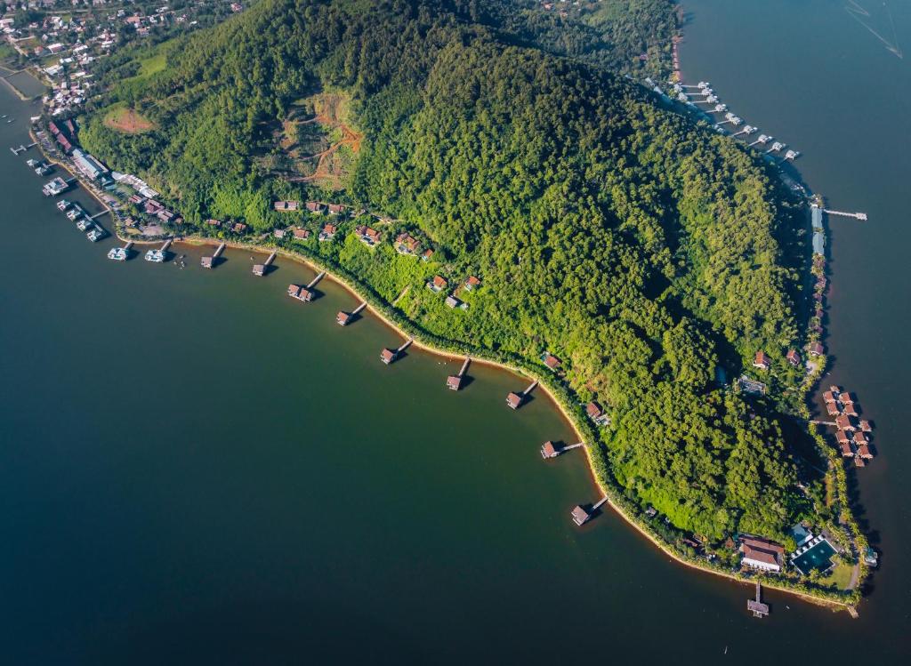 an island in the water with a group of houses at Vedana Lagoon Resort & Spa in Hue