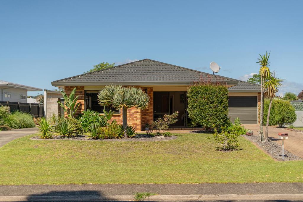 a house with a lawn in front of it at Family Friendly-Whitianga in Whitianga