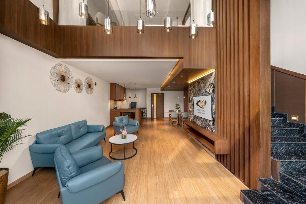 A wood-panelled lounge offers blue seating beside a staircase and television feature wall.