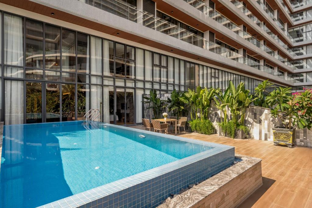 A rectangular outdoor pool sits beside a landscaped deck and the resort building.