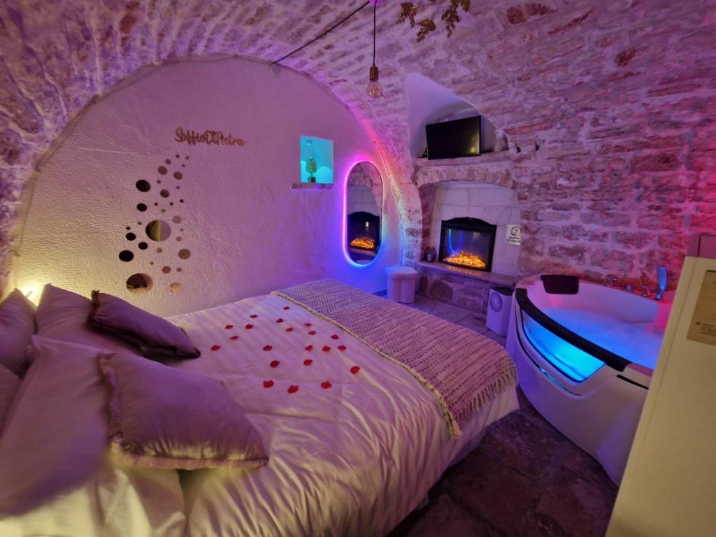 a bedroom with a bed and a tub in it at Soffio di Pietra in Castellana Grotte