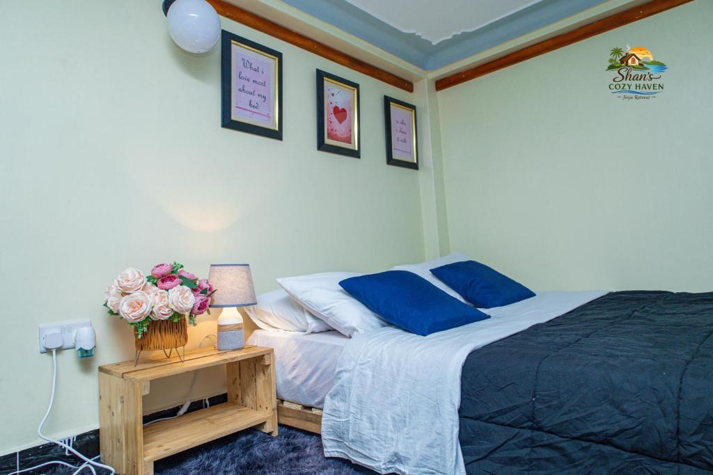 a bedroom with a bed and a table with flowers at Shan cozy haven in Jinja