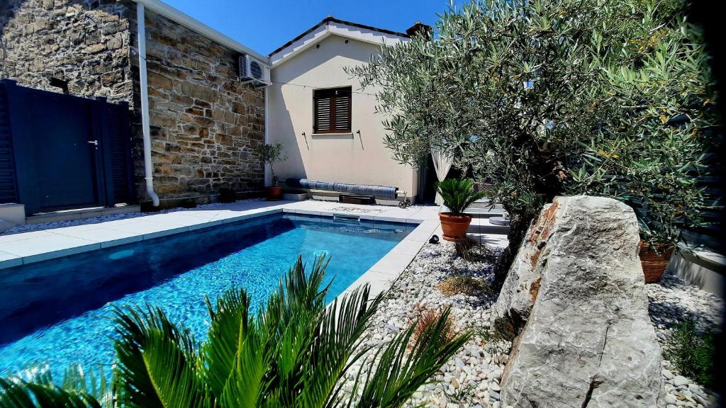 a swimming pool in front of a house at Villa Nostalgia - with private heated pool, jacuzzi and sauna in Koper