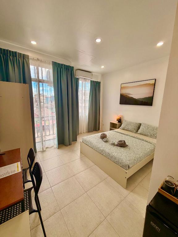 a bedroom with a bed and a large window at Drift Inn Kata Beach, Guest House in Kata Beach