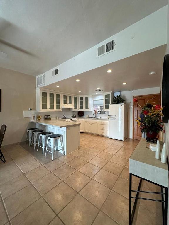 a large kitchen with white appliances and tables and chairs at Almost heaven beach house in Puerto Peñasco