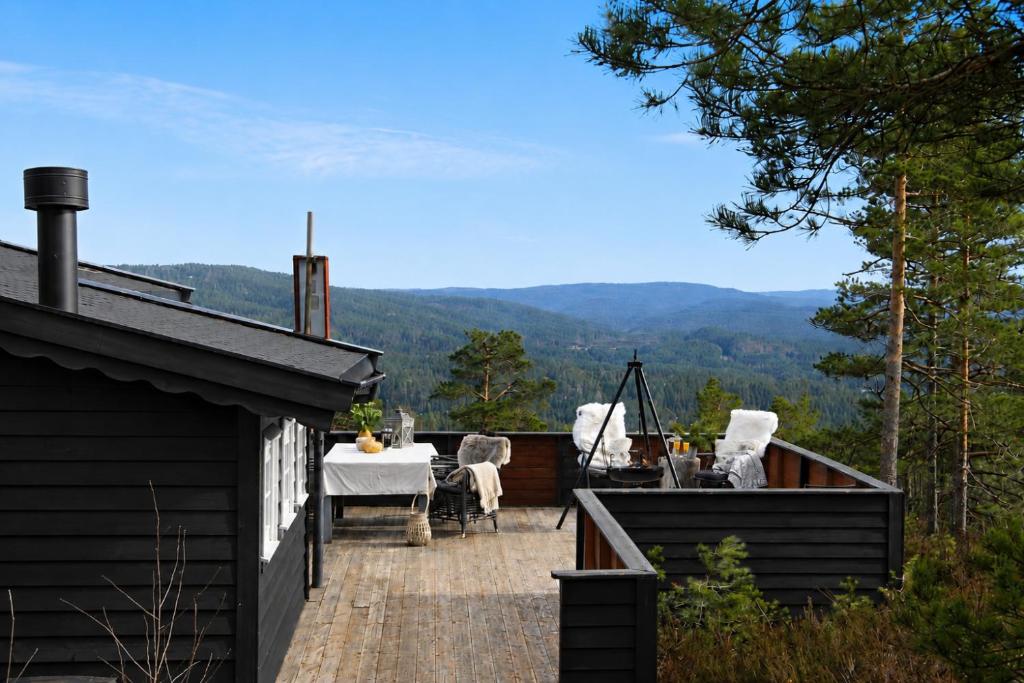a patio with a table and chairs on top of a house at Cozy cottage with a Wonderful view - Hiking trails - Silence in Mjåvatn