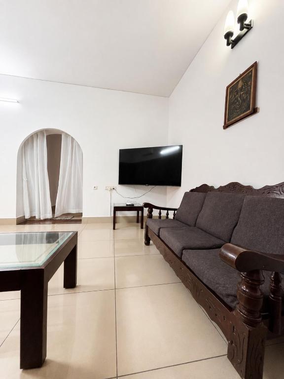 a living room with a couch and a flat screen tv at 3bhk villa in Lalbagh in Mangalore