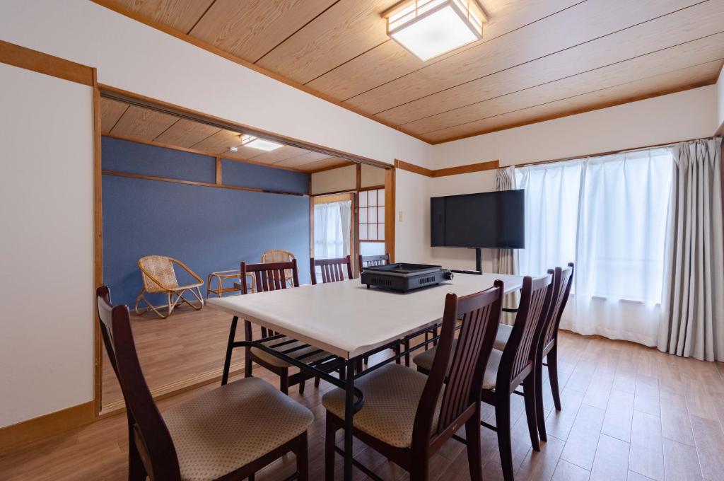 a dining room with a table and chairs at Shima Yadori Nagomi in Oshima