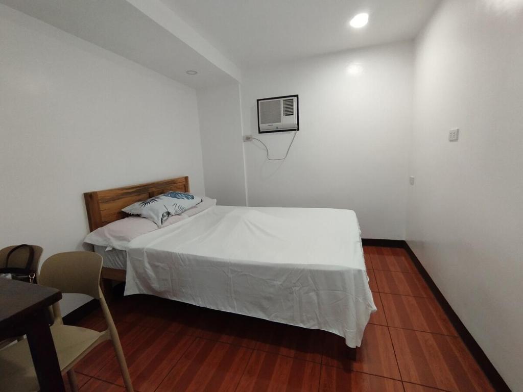 a bedroom with a white bed and a basketball hoop at TDGuestRoom Siargao in Dapa