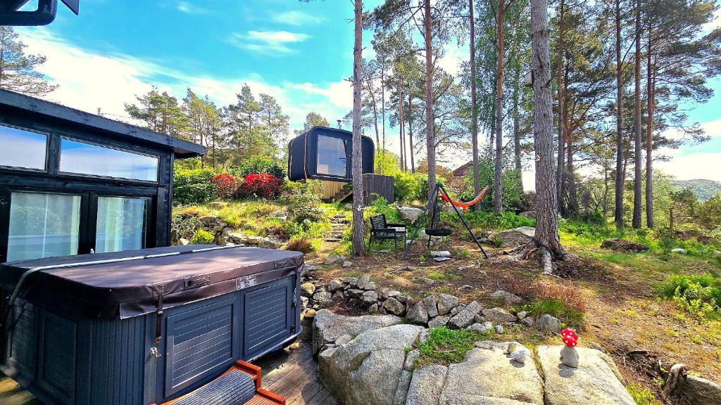 a tiny house in a garden with a tree at Animal trail in Sandnes