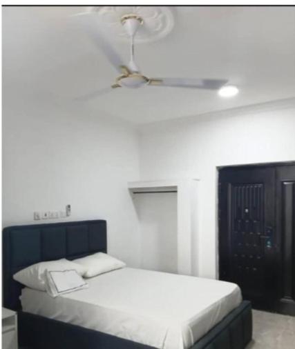 a bedroom with a bed and a ceiling fan at Meg place in Amamoli