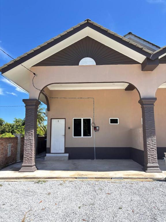 a garage with a white door in a building at Arkan Cottage in Kampong Tok Saboh
