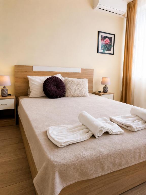 a bedroom with a large bed with towels on it at ApartmentDanny in Hisarya