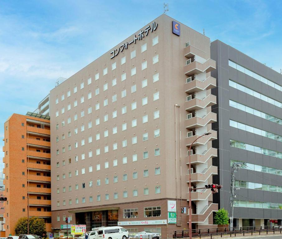 a building with a sign on the top of it at Comfort Hotel Sendai East in Sendai
