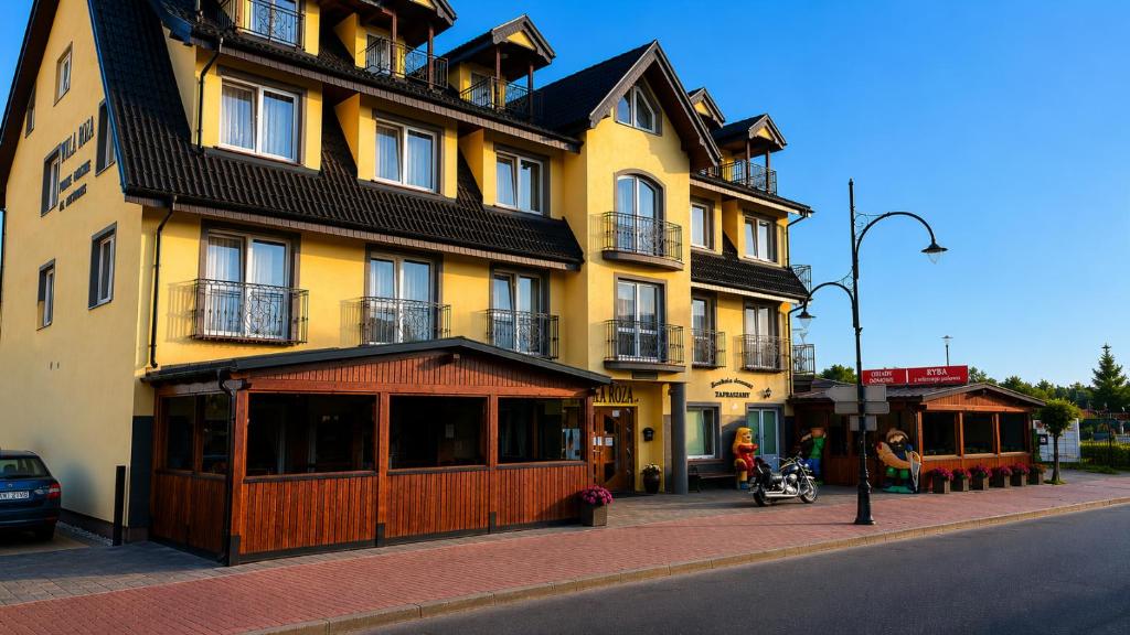 a large yellow building on the side of a street at Willa ROZA in Łeba