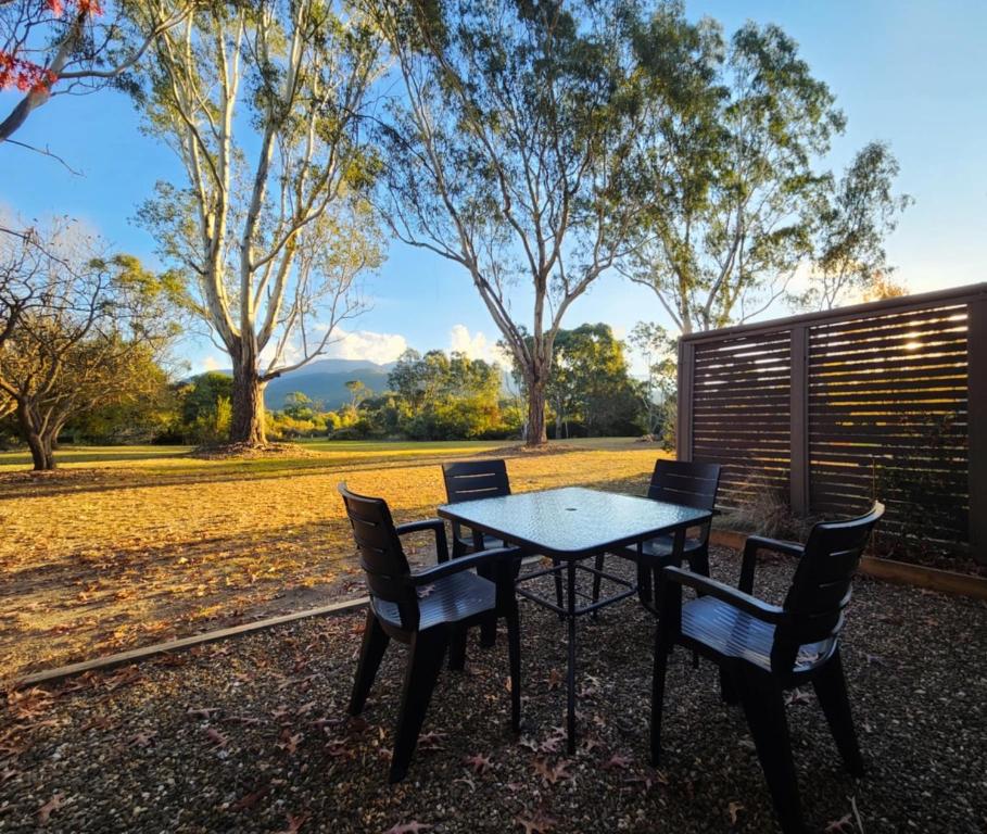 a table and chairs in a yard with trees at Restaway Holiday Units in Porepunkah