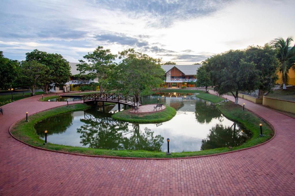 a park with a pond with trees and a bridge at Hotel Faranda Guayacanes, a member of Radisson Individuals in Chitré