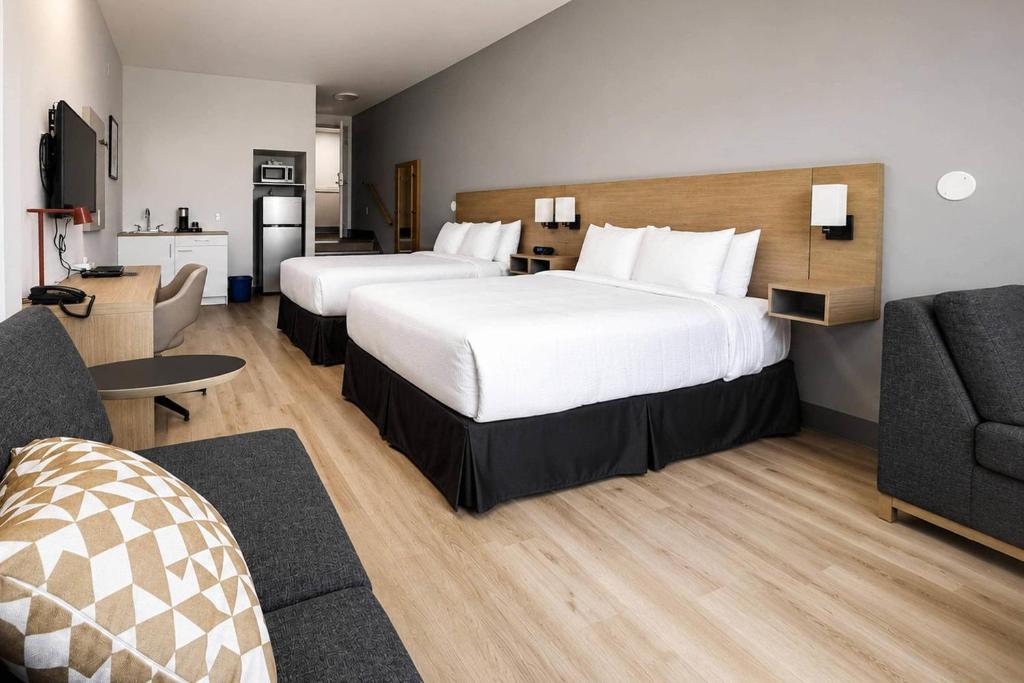 a hotel room with two beds and a couch at Maritime Inn Port Hawkesbury in Port Hawkesbury
