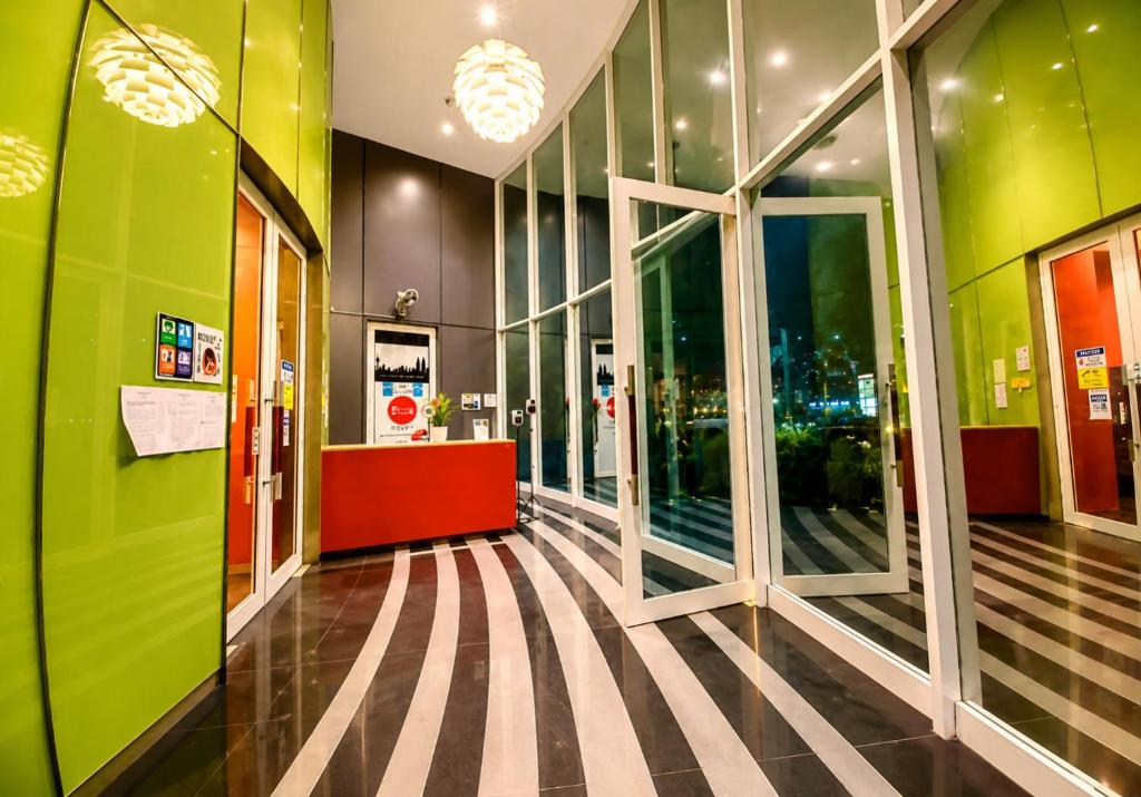 a hallway of a building with green walls and windows at vortex Suites KLCC KL in Kuala Lumpur