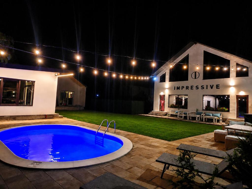 a swimming pool in the middle of a yard at night at Impressive Târgu Ocna in Târgu Ocna