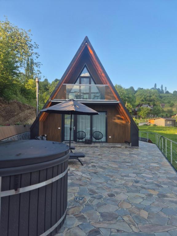 a small house with an umbrella and a patio at Panoramic Nicolas in Borsa