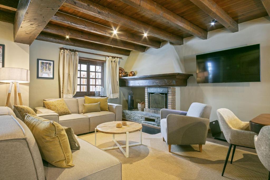 a living room with a couch and a fireplace at Luderna - Casa con terraza Cuylas in Baqueira-Beret