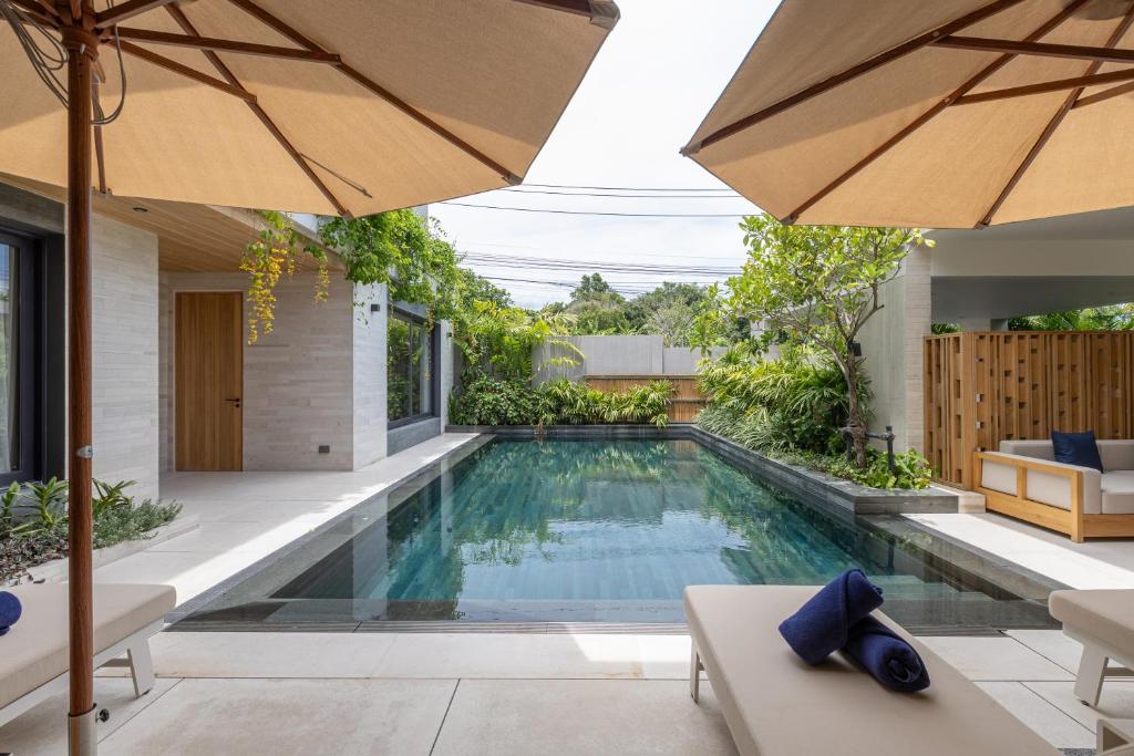 an infinity pool in a house with an umbrella at Layana Residence in Layan Beach