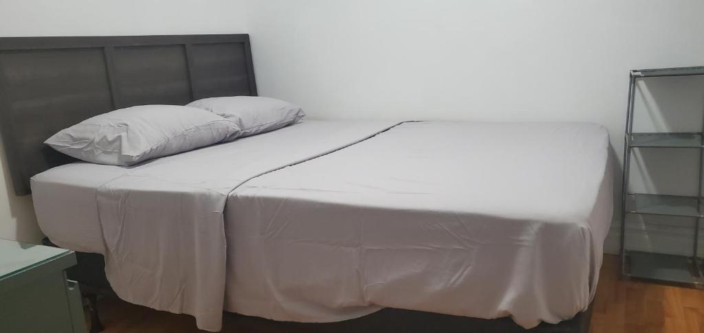 a bed with white sheets and pillows on it at E3 Hostings in Hamilton