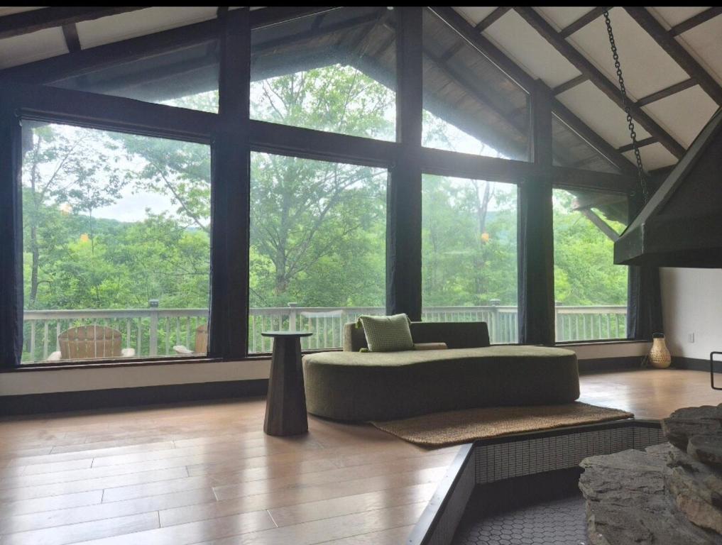 a living room with a couch in front of a large window at Lumen Catskill NY in Roscoe