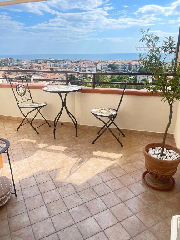 a balcony with two chairs and a table and a plant at Marina Panoramic Sea View in Scalea