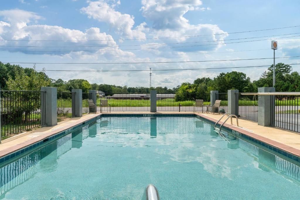 a swimming pool in a yard with a fence at Quality Inn Adairsville-Calhoun South in Adairsville