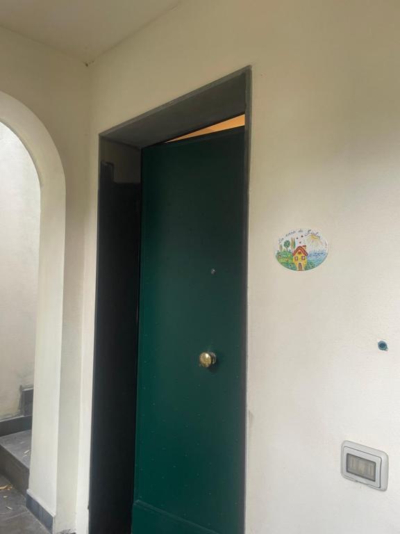 a green door with a sticker on the wall at La casa di Giulia in Genoa