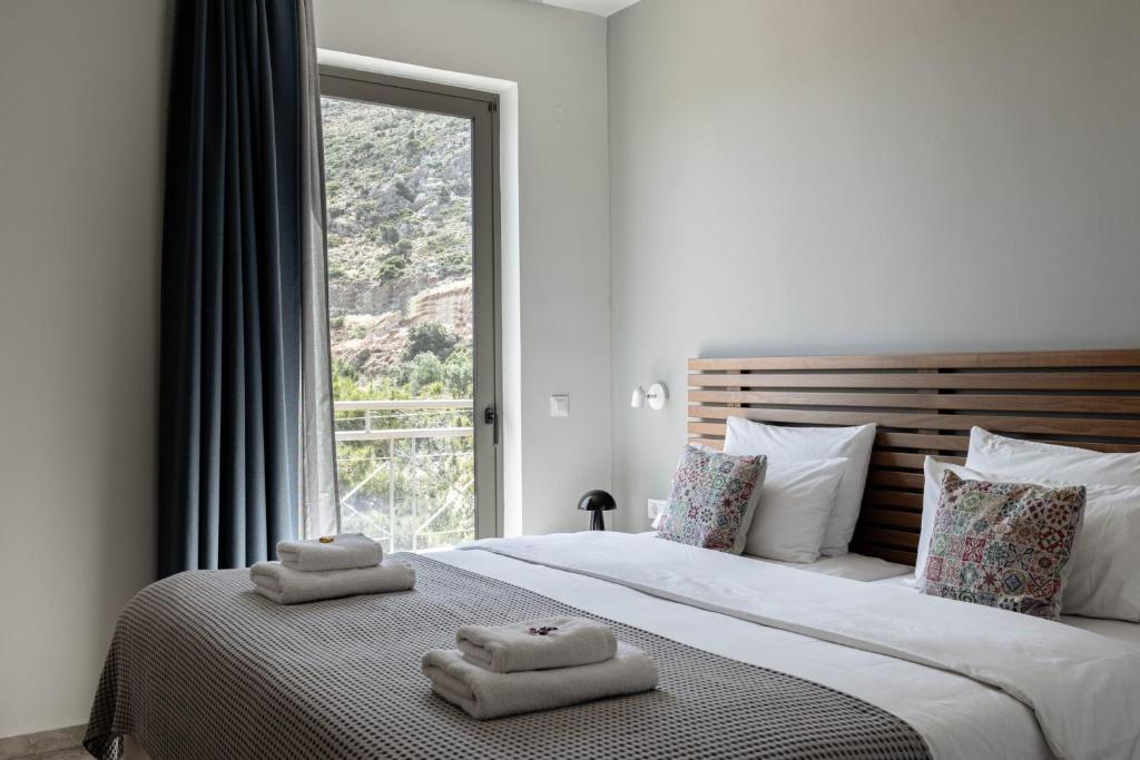 a bedroom with two towels on a bed with a window at Bella Vista Hotel "by Checkin" in Hersonissos