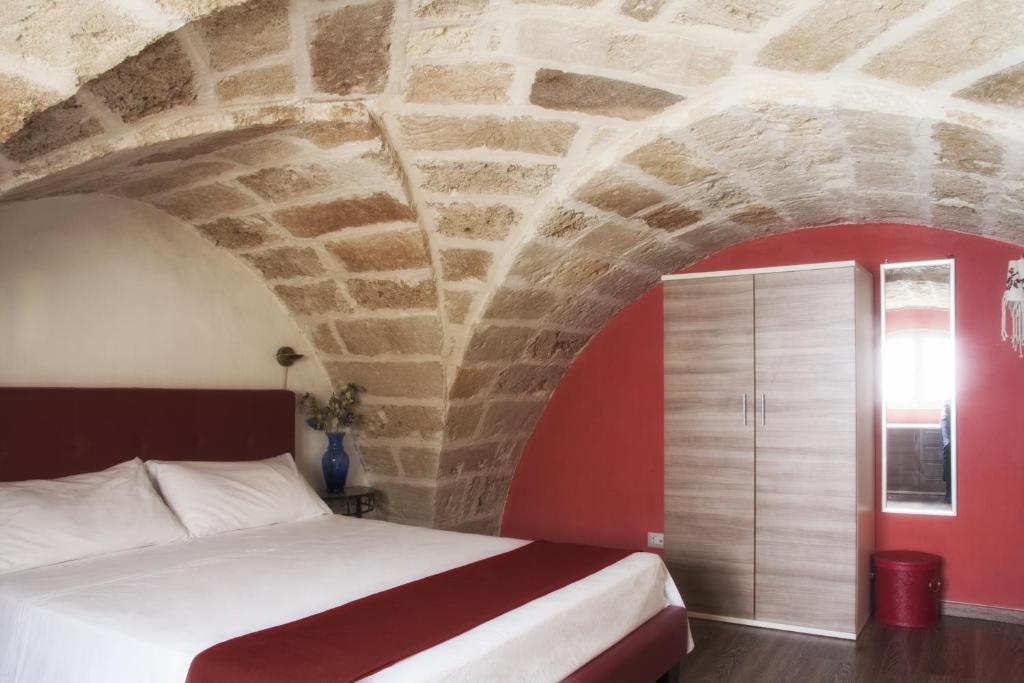 una camera con letto e parete rossa di Dimora Romantica a Ugento