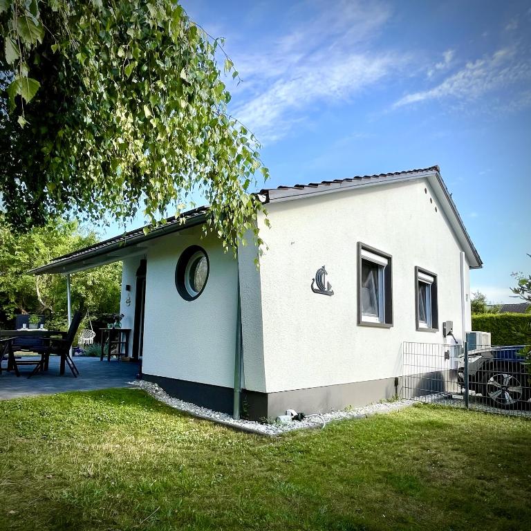 a small white house with a patio in a yard at Koje47 in Scharbeutz