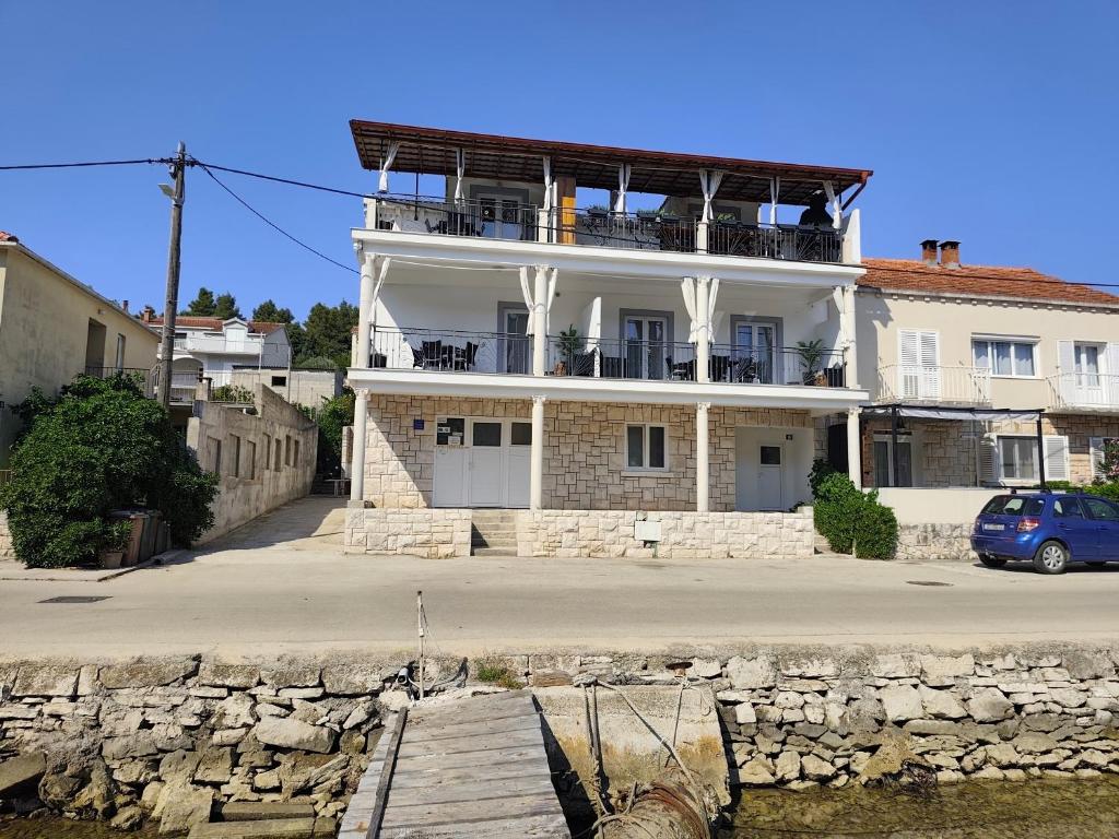a white building with a balcony on top of it at Villa Korčula in Vela Luka