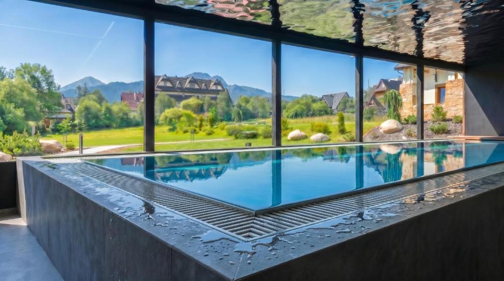 a swimming pool with a view of a house at Rezydencja Zakopane in Zakopane