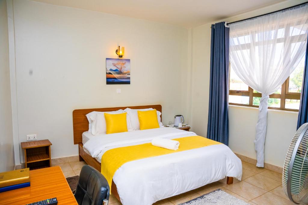 a bedroom with a large bed and a window at Sai Inn Eldoret in Eldoret