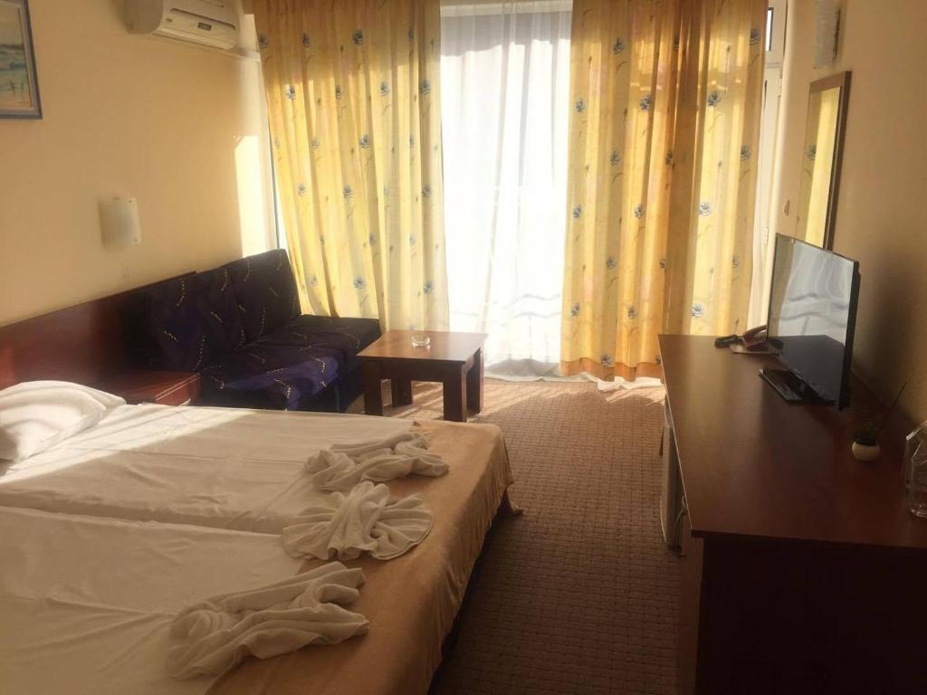 a hotel room with a bed and a couch at Family Hotel Eliri in Nesebar