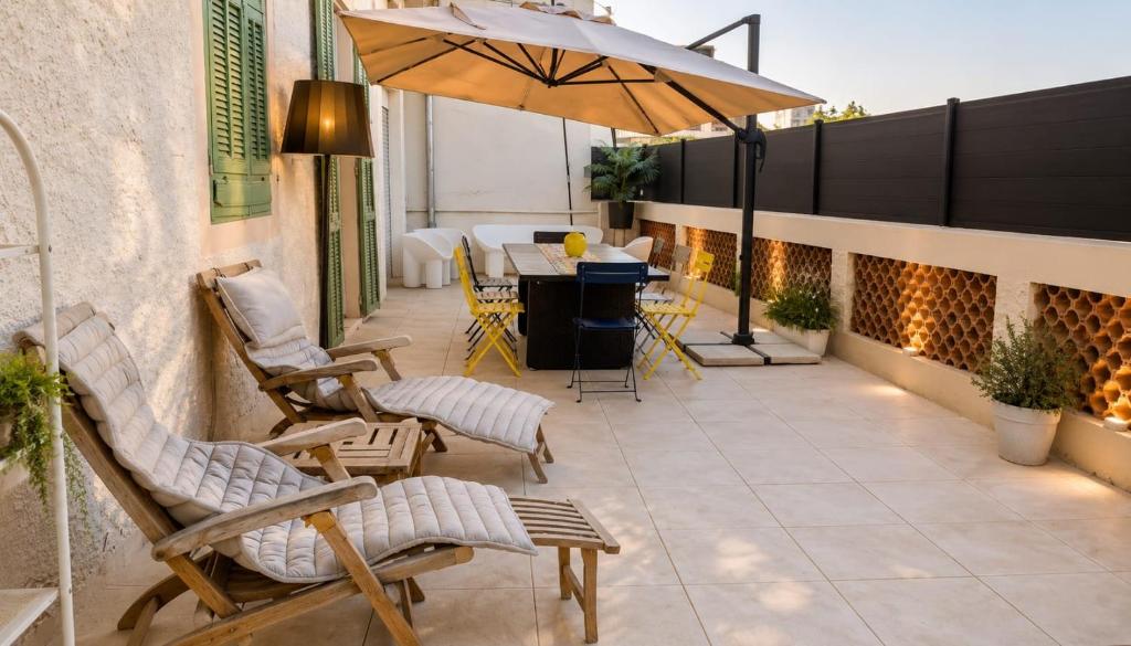 a patio with chairs and a table and an umbrella at Sunset Villa atypical with air conditioning in Nice