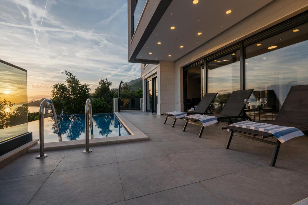 a house with a swimming pool and a patio at Villa LUX 55 in Tučepi