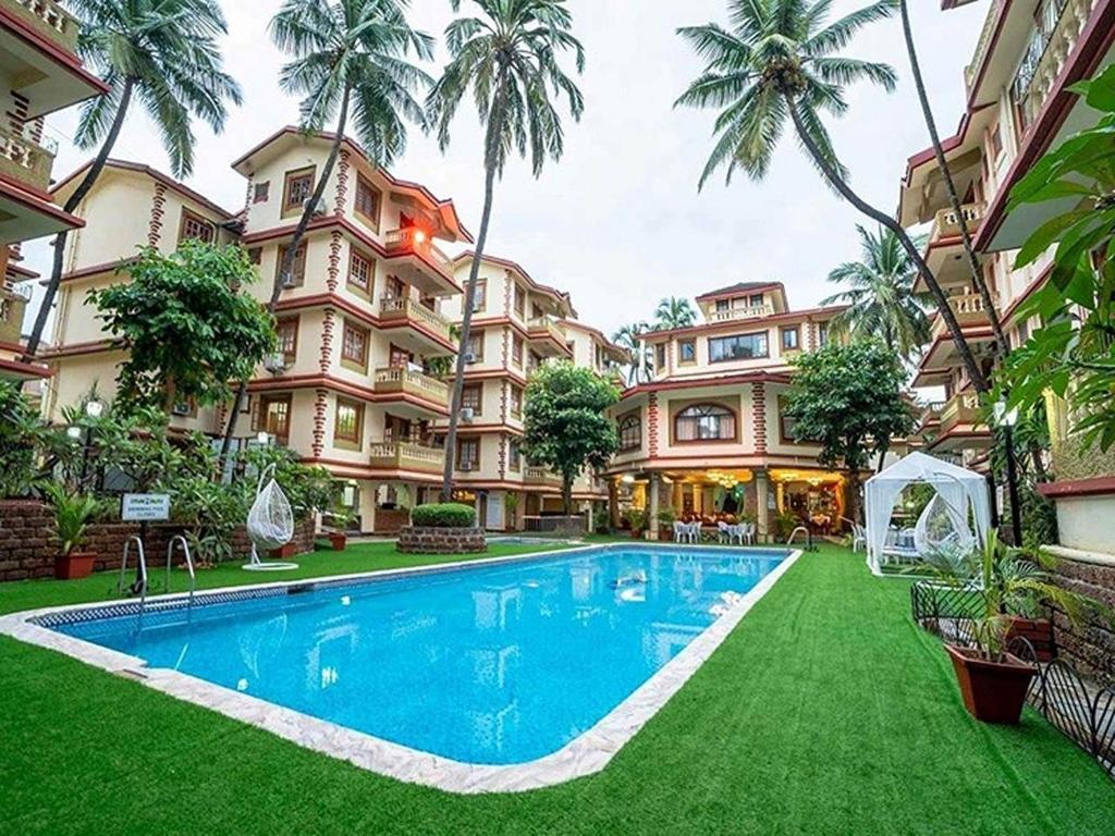 a resort with a swimming pool in front of a building at Palette Susegad I 3BHK Apartment I Pool I Candolim I GOA in Candolim