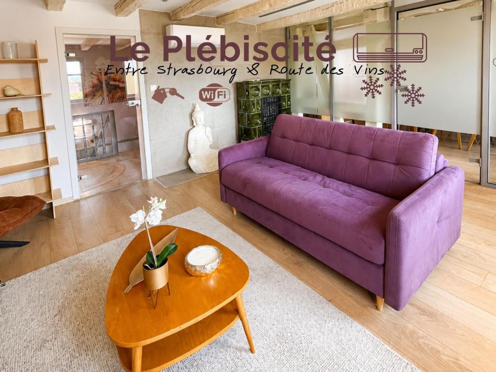 a purple couch in a living room with a table at Le Plébiscité Maison Premium sur la Route des Vins d'Alsace in Marlenheim