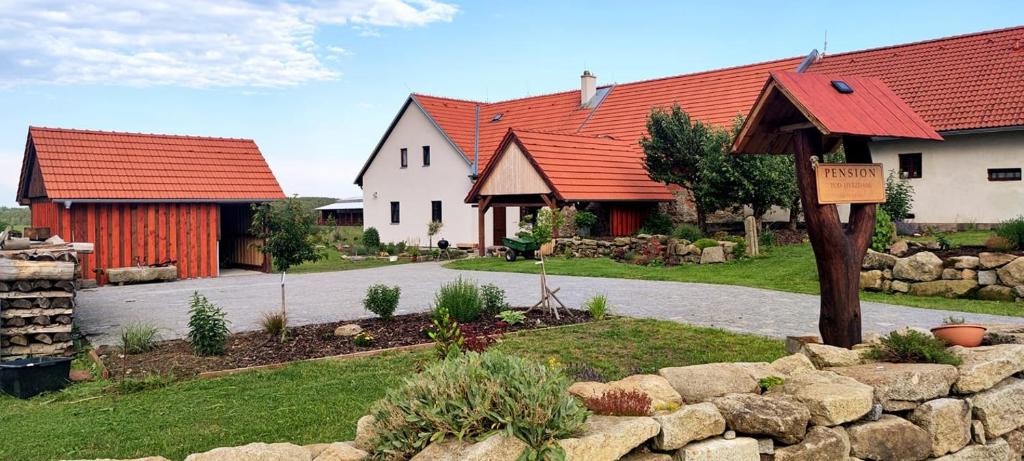 a house with red roofs and a stone wall at Pension Pod Hvězdami in Božejov