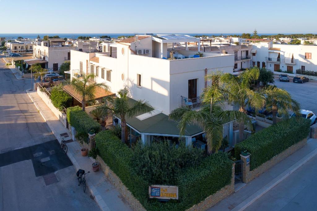 an overhead view of a white building with palm trees at Athena Bed & Breakfast in San Vito lo Capo