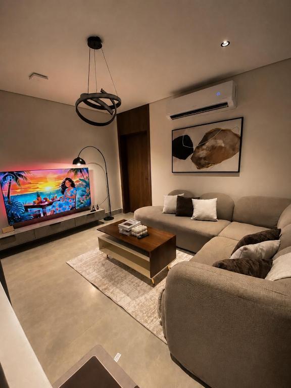 a living room with a couch and a tv at سويت مسك غرفة وصالة بلمسة عصرية راقية in Dammam